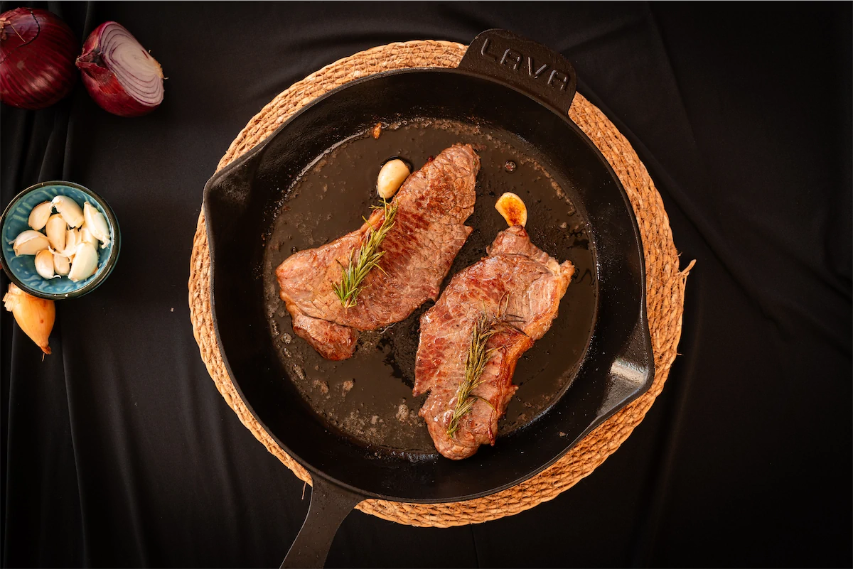 Steaks in a cast iron pan.