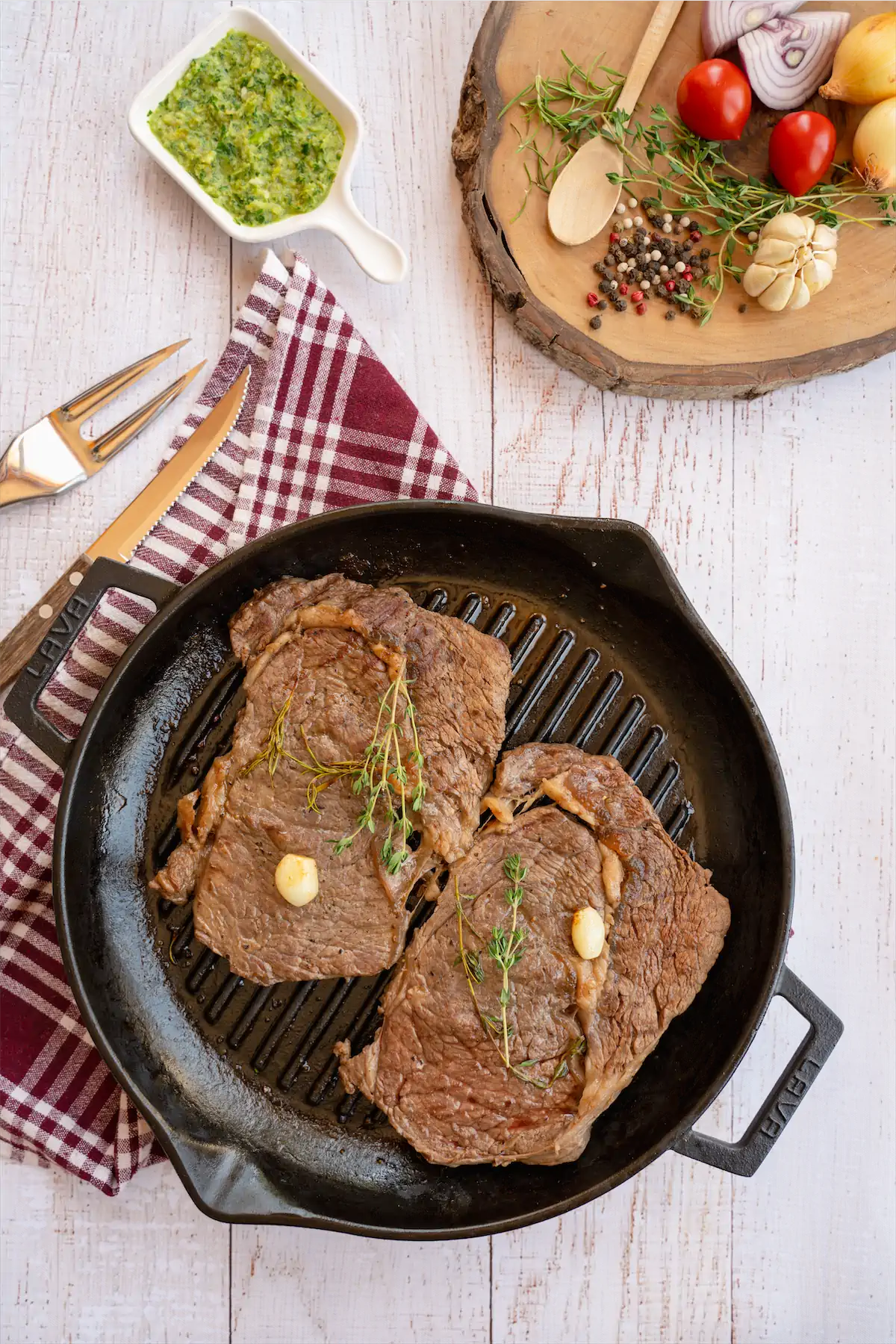 Freshly grilled sirloin steak recipe in a grill pan on kitchen table.
