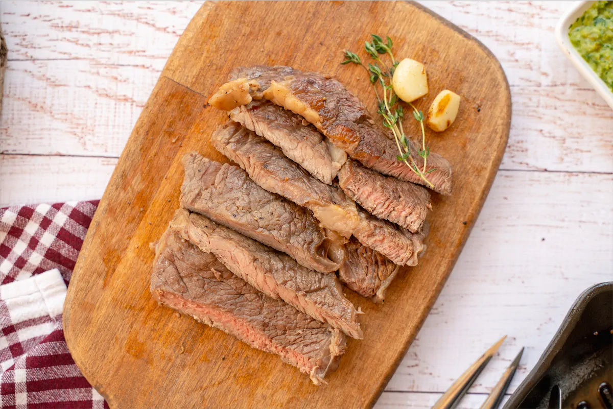Homemade sirloin steak slices on a wooden serving board.
