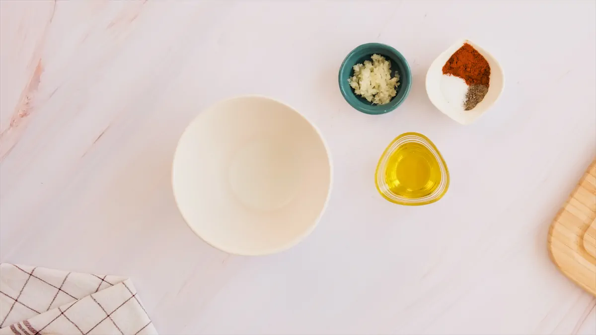 Bowl next to olive oil, minced garlic, paprika, salt, and black pepper.