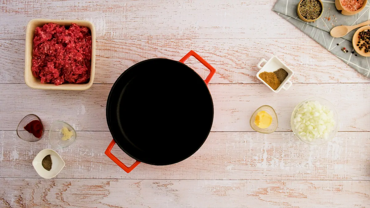 Cast iron skillet between different ingredients on kitchen table.