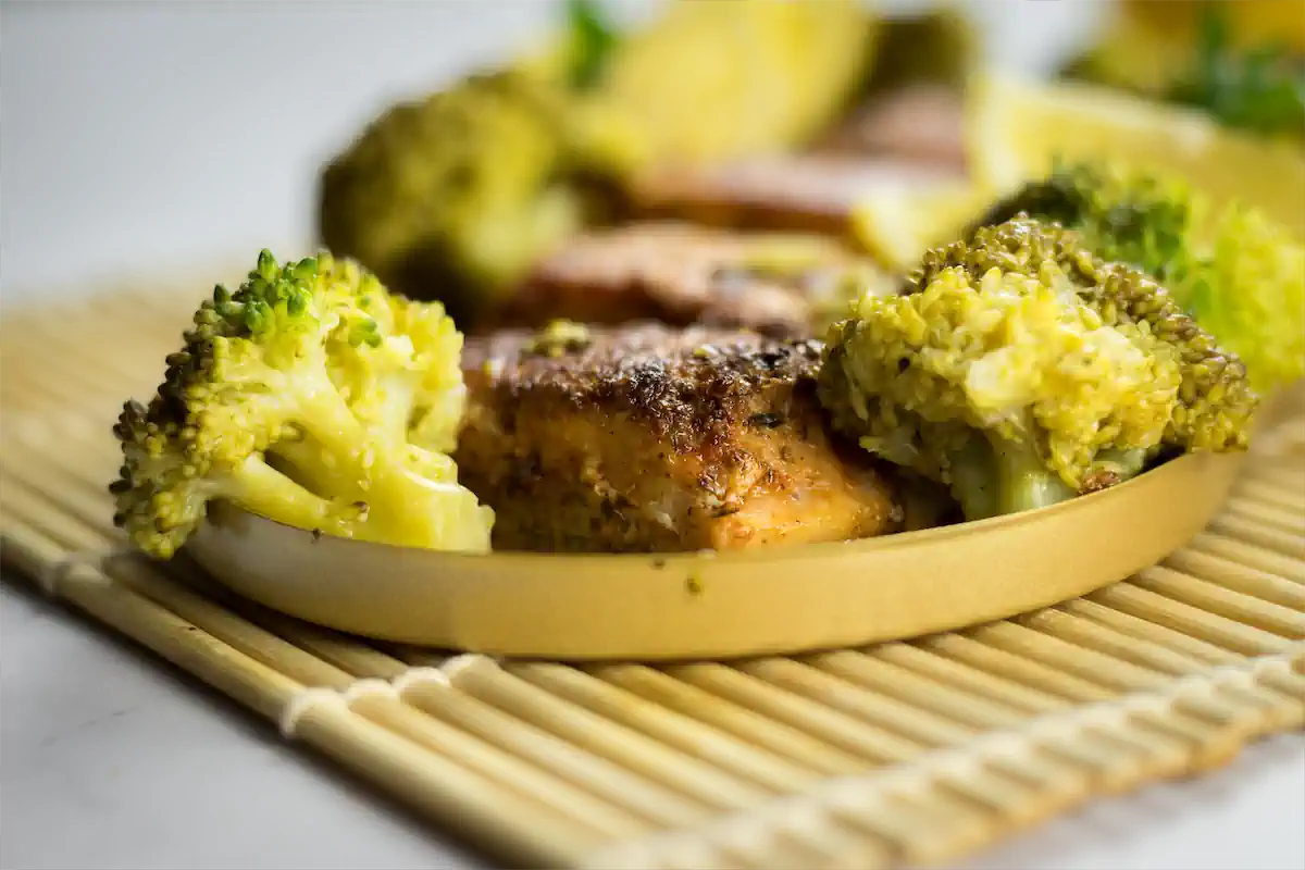 Blackened salmon served with broccoli on a plate.