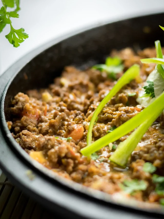 Low-carb taco casserole in a skillet garnished jalapeño with green herbs.
