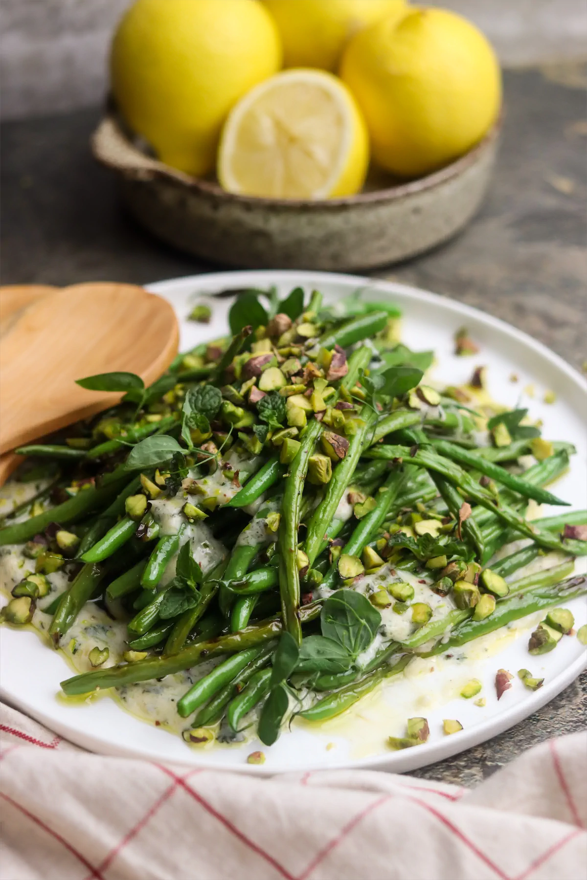 Ready to serve grilled green bean salad with yogurt and mint-dressing on a plate.