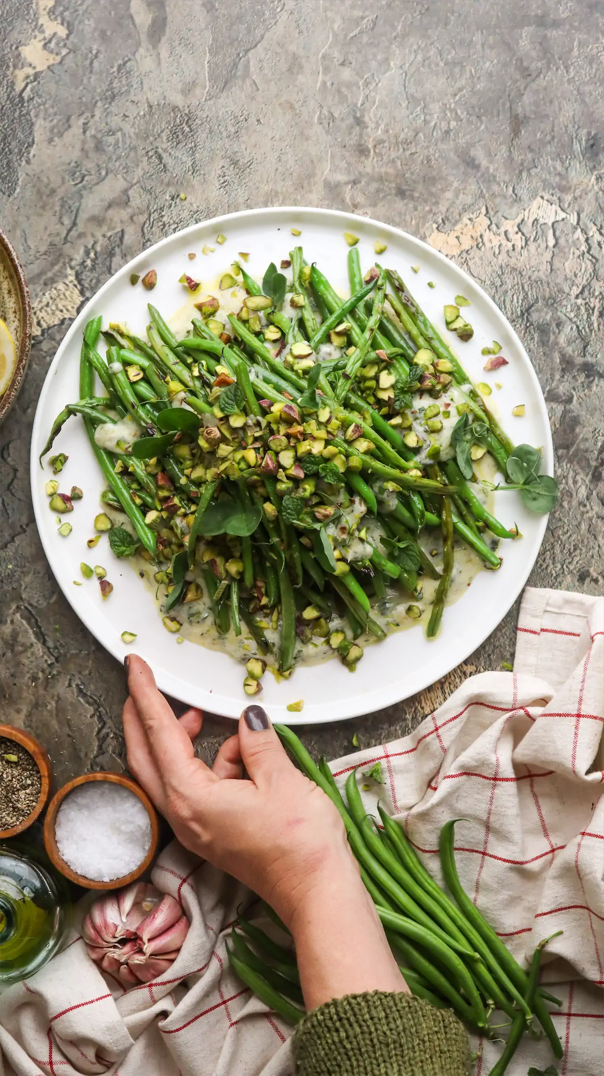Grilled green bean salad, dressed with yogurt and mint, garnished with pistachios on a plate.