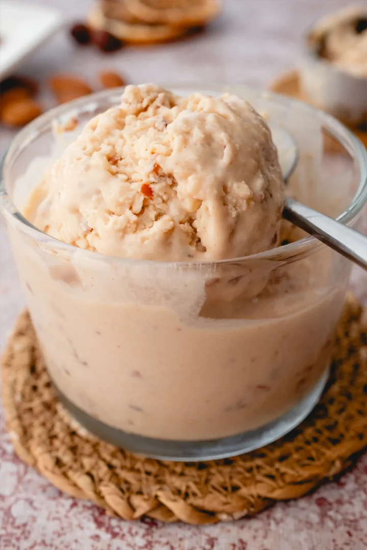 Homemade ice cream with butter and pecan served in a glass bowl and a spoon.