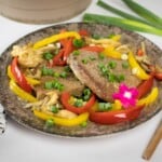 Keto pork steak with oyster mushrooms and bell peppers served on a plate.