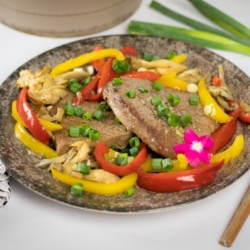 Keto pork steak with oyster mushrooms and bell peppers served on a plate.