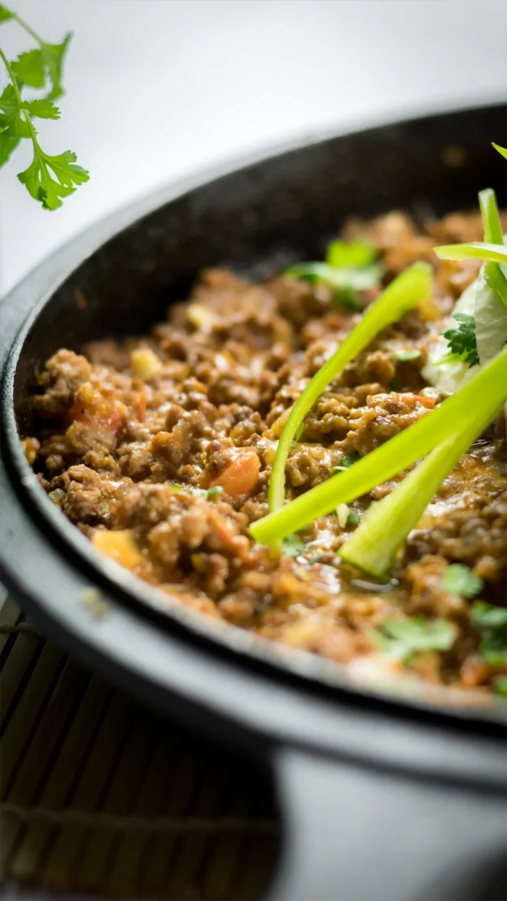 Low-carb taco casserole in a skillet garnished jalapeño with green herbs.