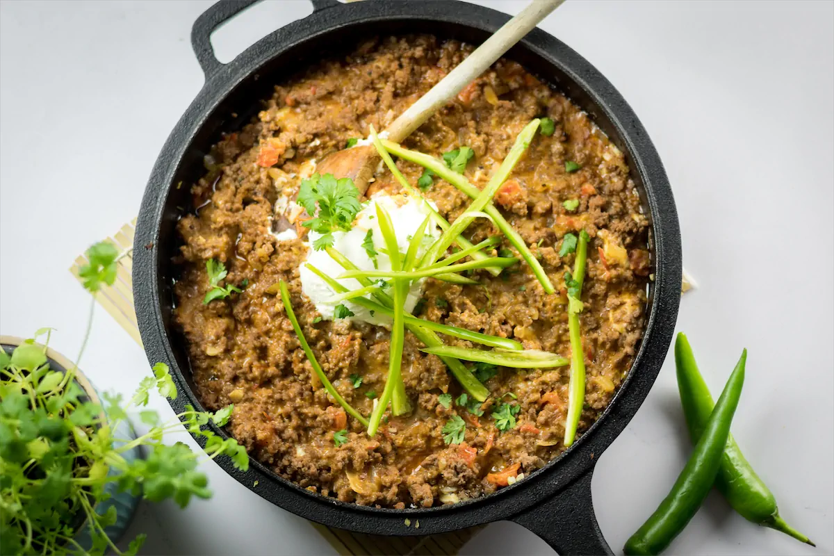 Low-carb keto taco casserole in a skillet ready to be served with a wooden spoon.