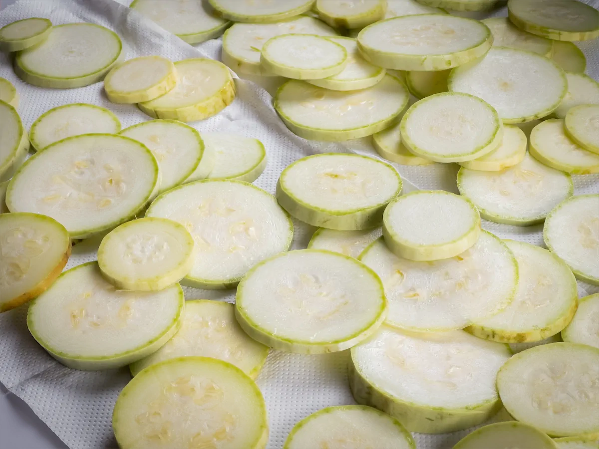 Zucchini slices drying on paper towels.