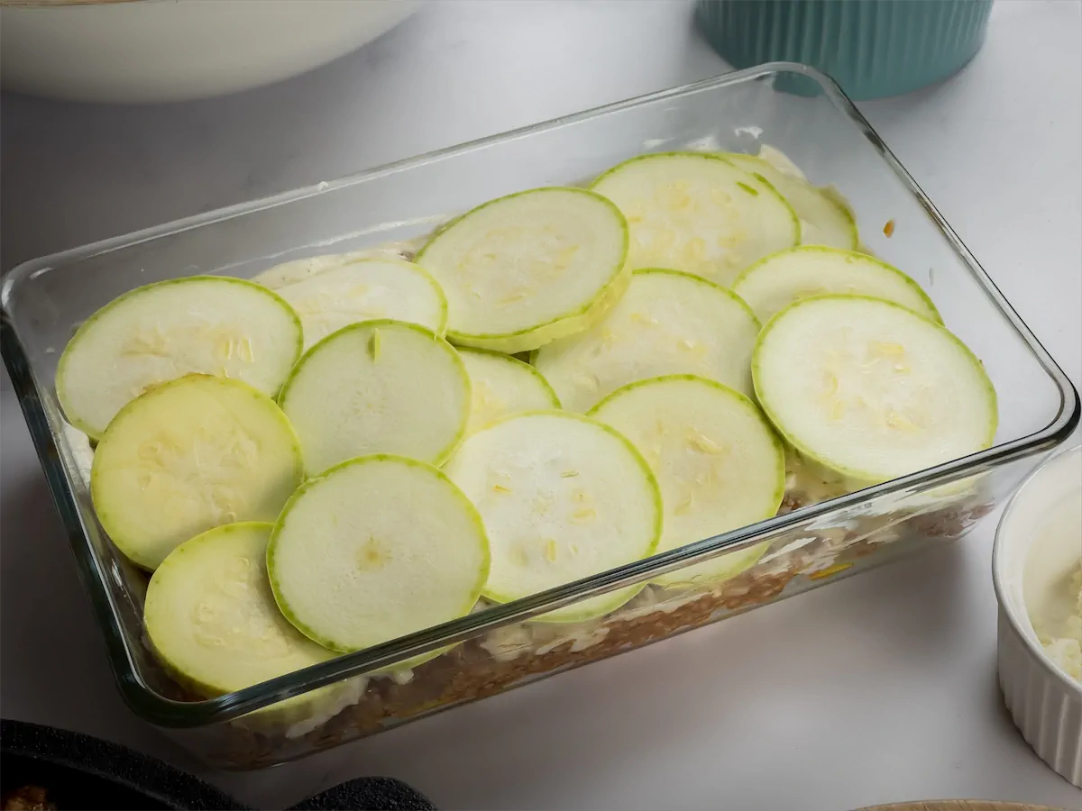 Top layer covered with the zucchini slices while preparing homemade lasagna.