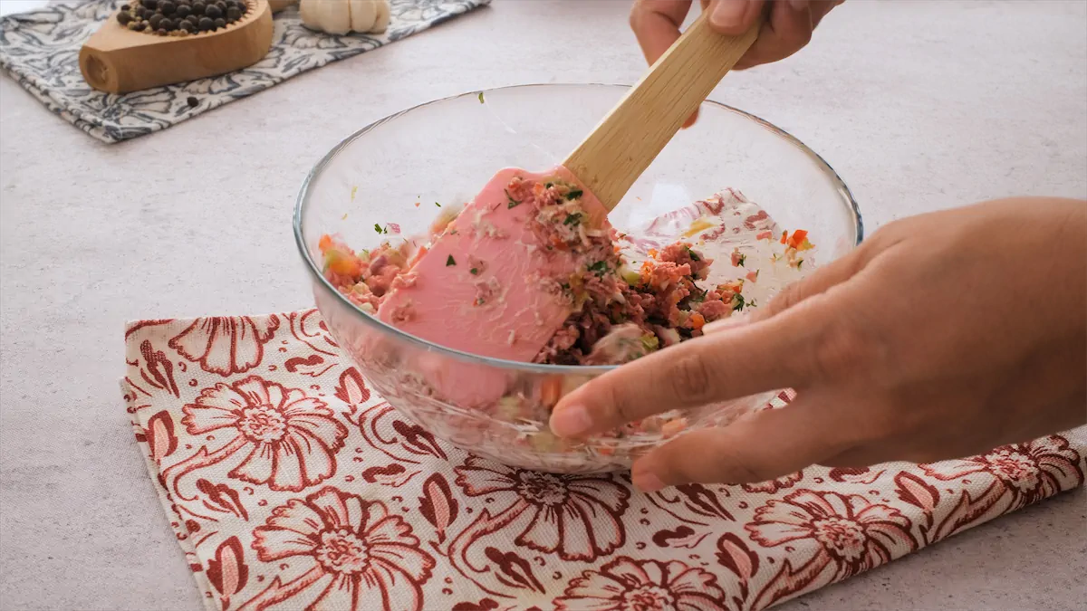 Mixing all the ingredients required for this old-fashioned ham salad in a big glass bowl.