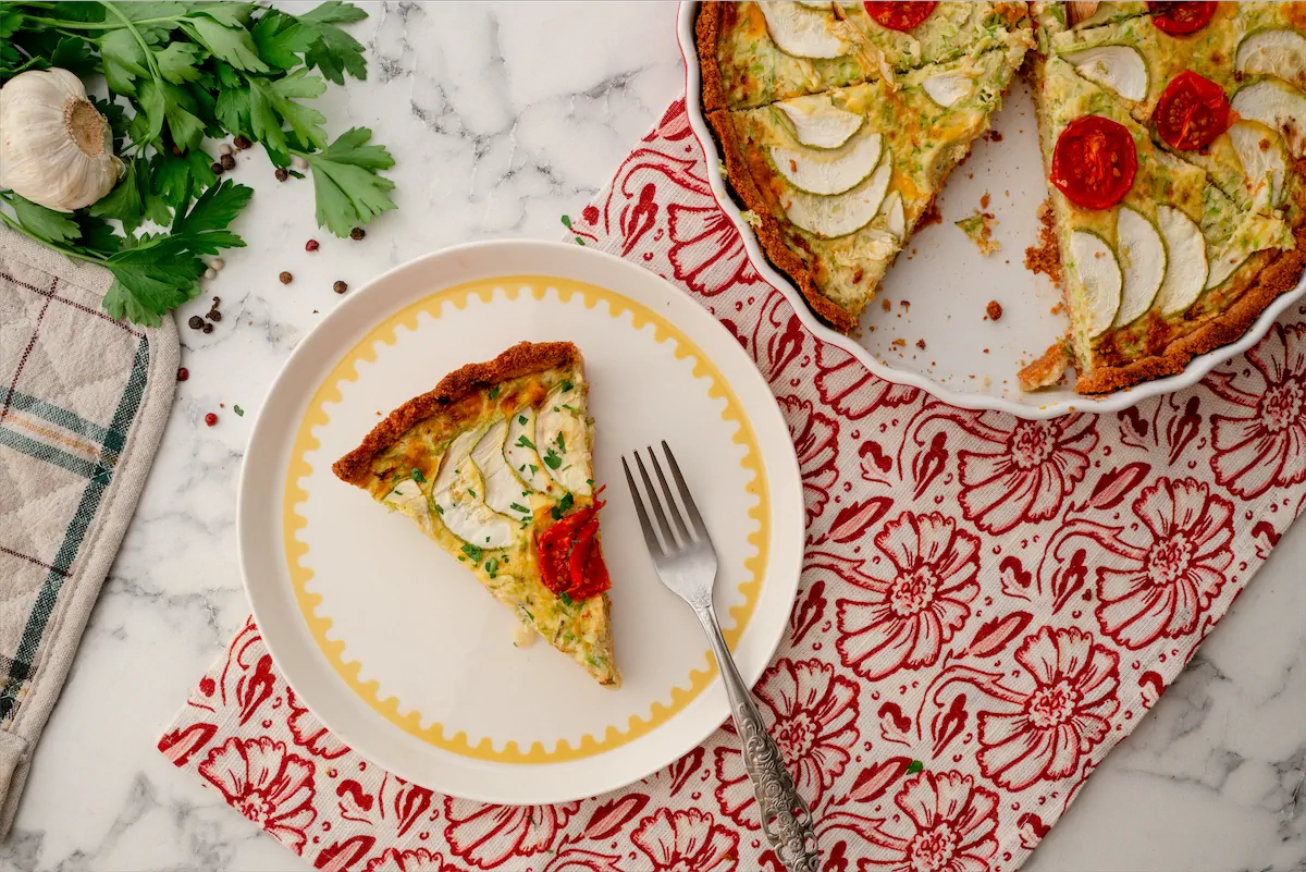 Homemade zucchini quiche served on a plate with a fork.