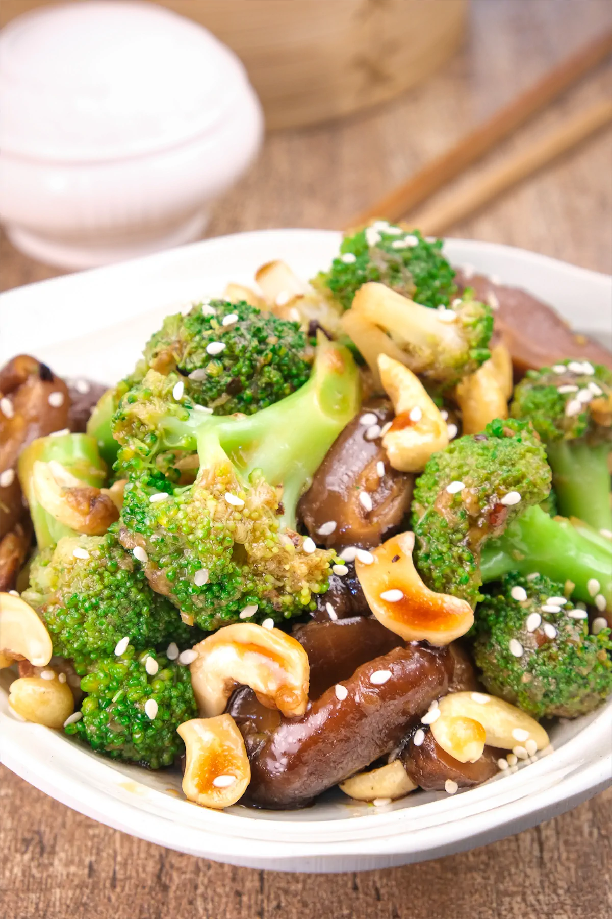 Low-carb broccoli and mushrooms in an Asian sauce presented in a bowl and garnished with cashews.