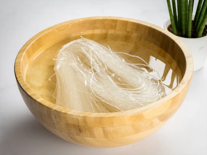 Soaking konjac noodles in water in a wooden bowl.