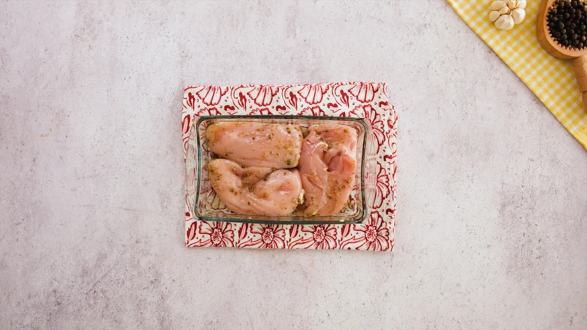 Marinated chicken in a rectangular glass bowl.