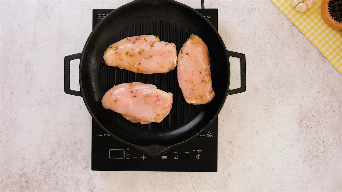 Cooking the marinated chicken breasts in the cast iron skillet.