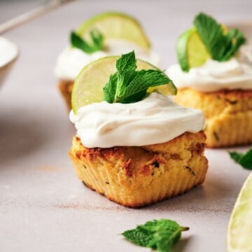 Homemade mojito-themed cupcakes, garnished with cream cheese frosting, a lemon wedge, and mint leaves.