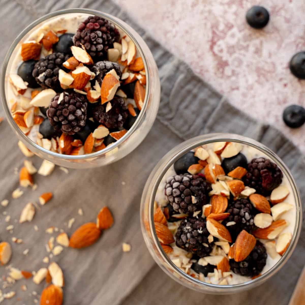 Overnight oats topped with nuts and berries served in glass jars.