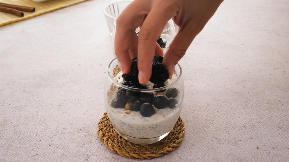 Berries getting topped in a glass jar with the overnight oats mixture.