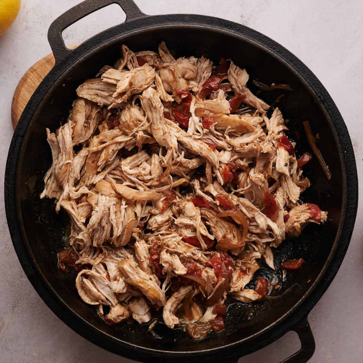 Cast-iron skillet with homemade keto pulled chicken ready to be served.