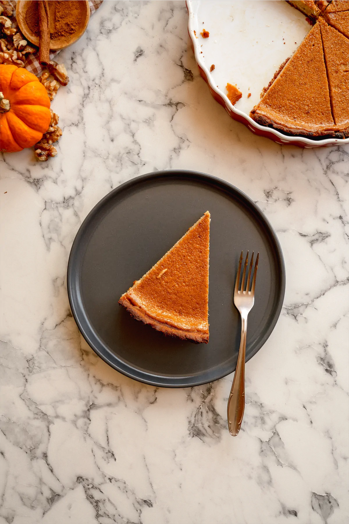 A slice of keto pumpkin pie served on a plate with a fork.