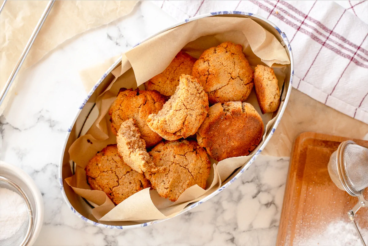 Homemade pumpkin spice cookies stored in an oval box lined with parchment paper.