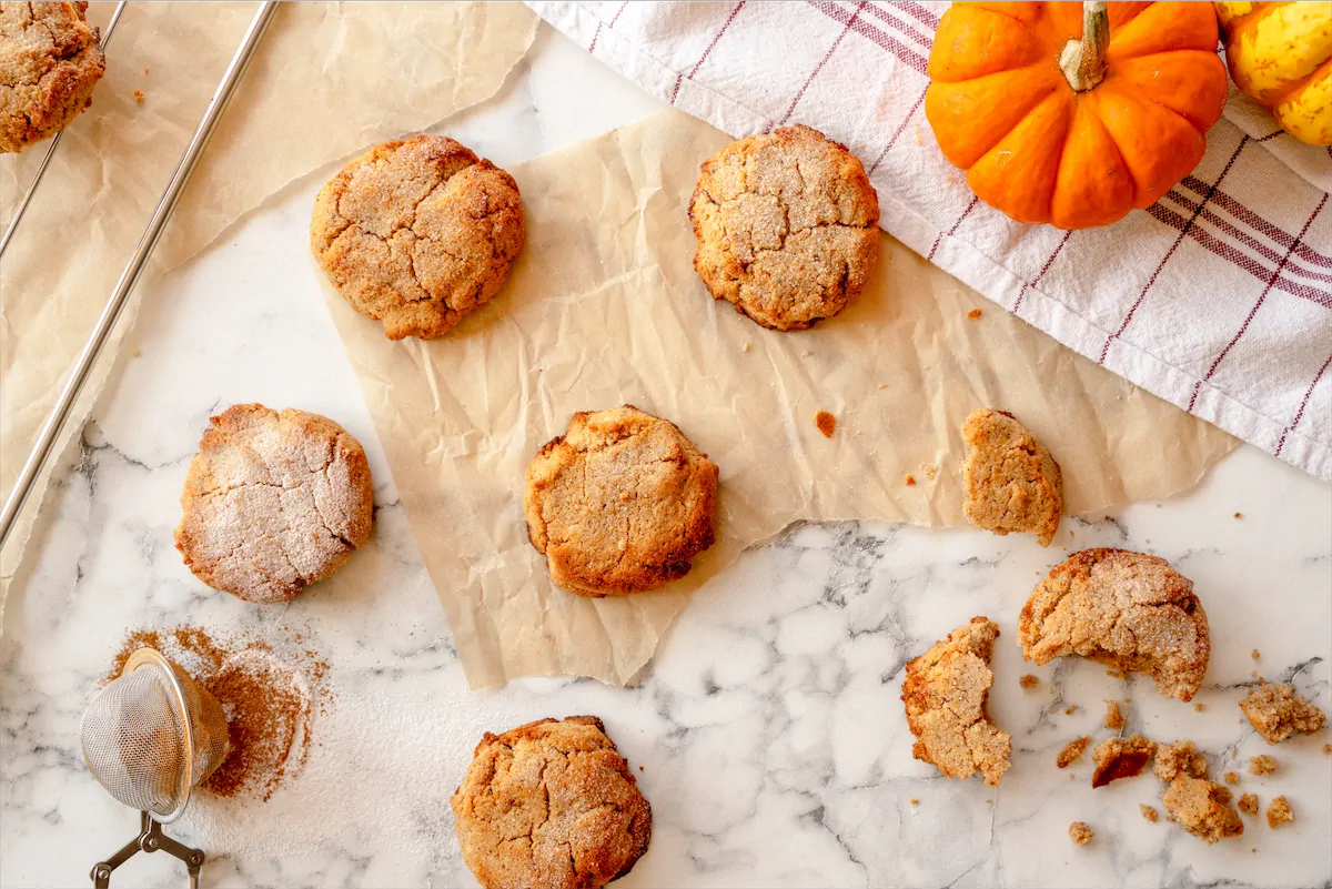 Homemade pumpkin spice cookies artfully displayed on the table while one is broken.