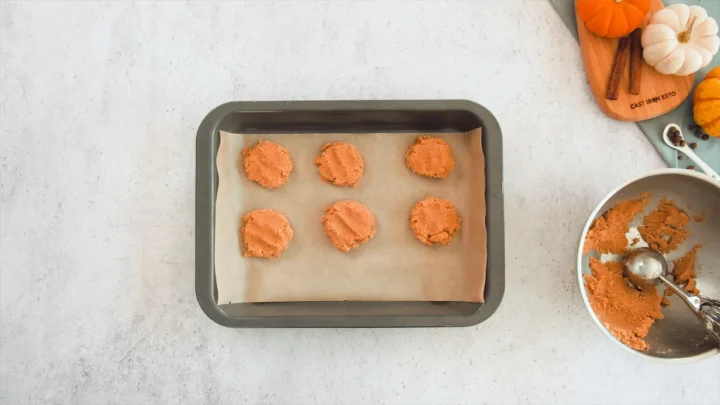 Parchment paper-lined baking tray filled with pumpkin spice cookies ready to be baked.