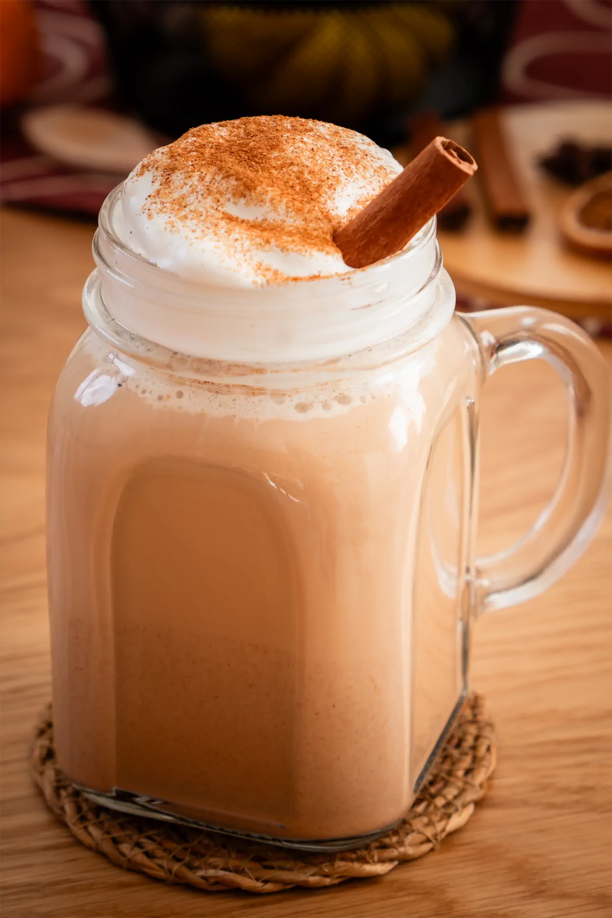 Homemade keto pumpkin spice latte recipe served in a mason jar finished with a dollop of whipped cream, a dash of pumpkin spice and a cinnamon stick.