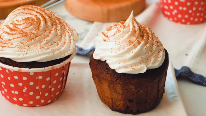 Homemade pumpkin spice latte cupcakes with whipped cream and a dash of pumpkin spice.
