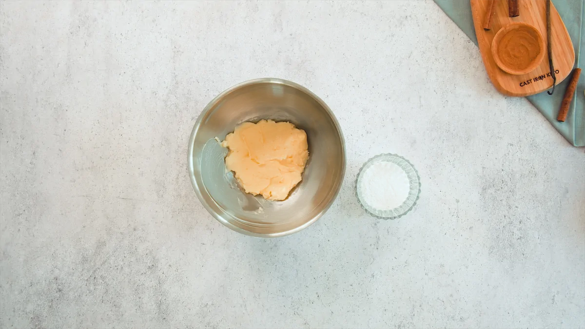 Softened butter in a mixing bowl beside a small bowl of granulated erythritol.