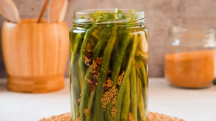 The glass jar containing the green bean pickles.