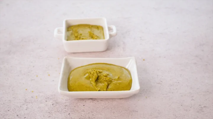 Homemade pistachio butter presented in white dishes.