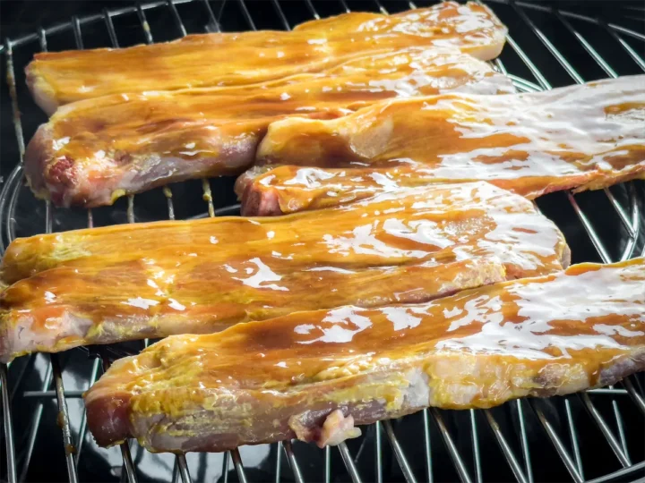 Pork ribs. brushed with BBQ sauce and yellow mustard laid and cooked in the smoker.