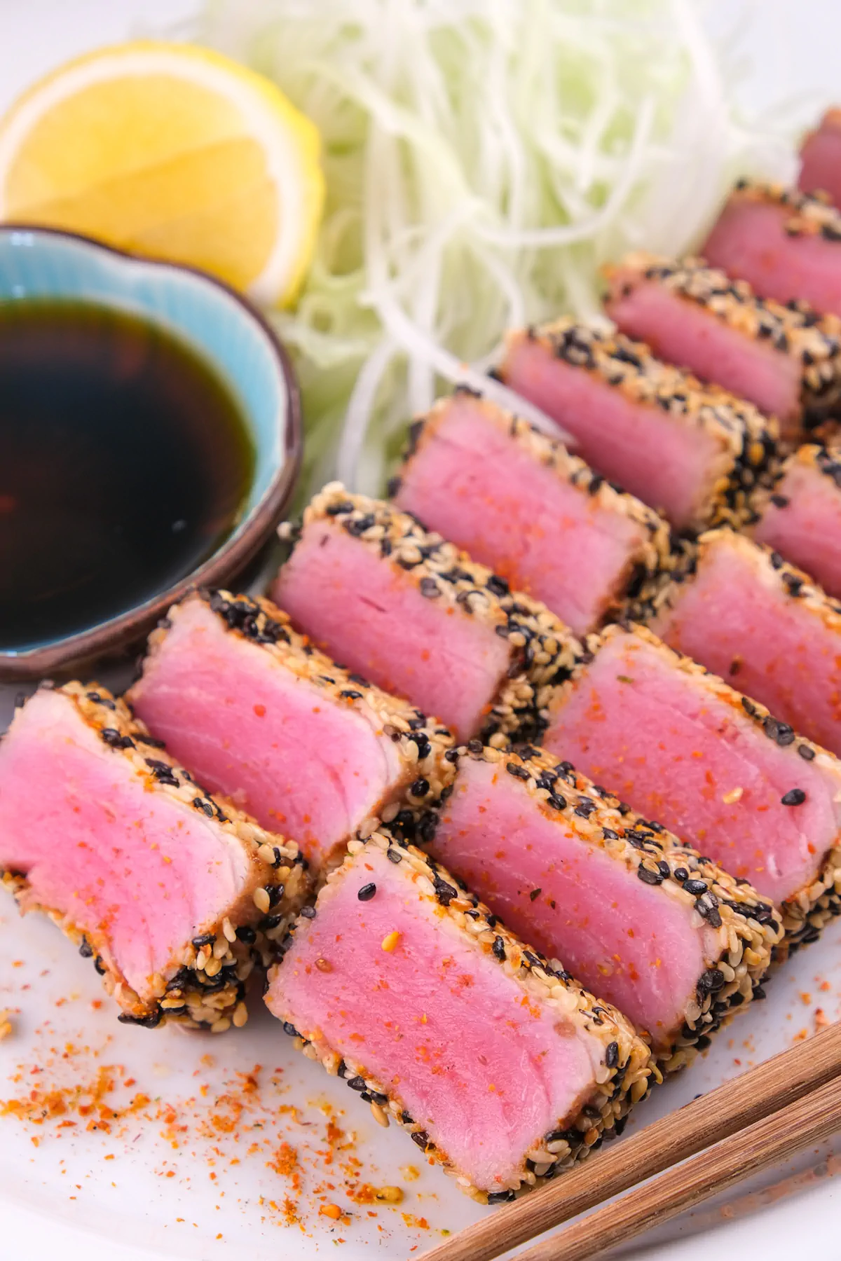 Slices of keto ahi tuna steak with a crispy sesame coating and a side of ponzu sauce.