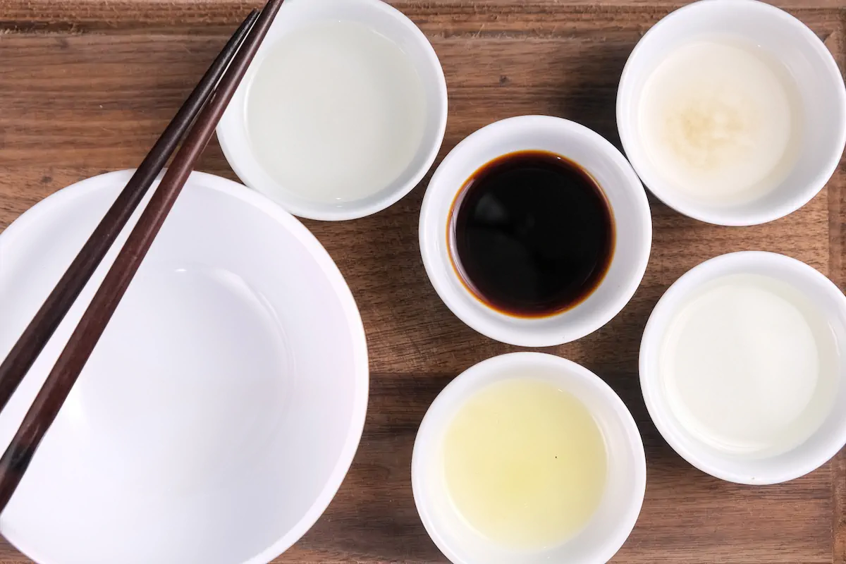 The required amount of fermented soy sauce, mirin, dashi, dashi stock, rice vinegar, and lemon juice gathered and arranged on the table.