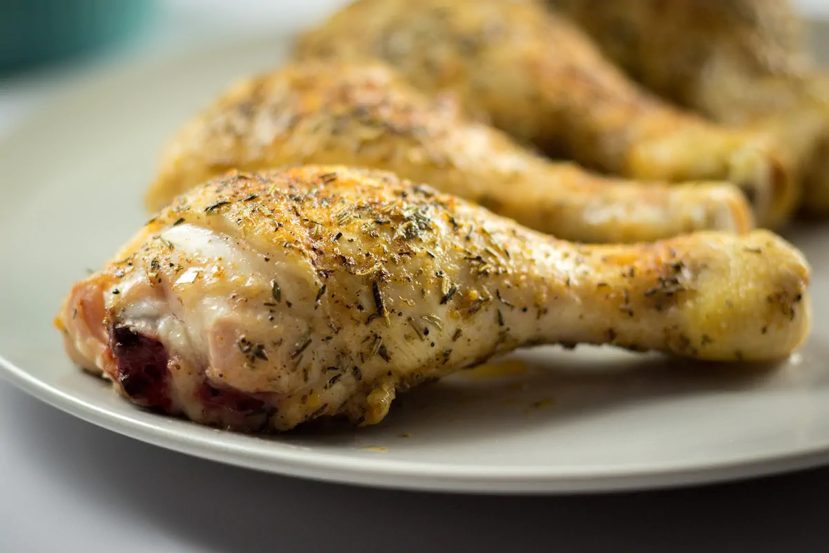 A closeup image of baked chicken legs coated with spices showcasing the texture.