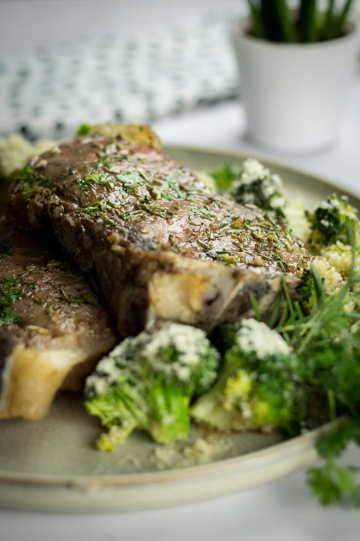 Homemade oven-baked ribeye steak with cheesy roasted broccoli, presented on a plate.