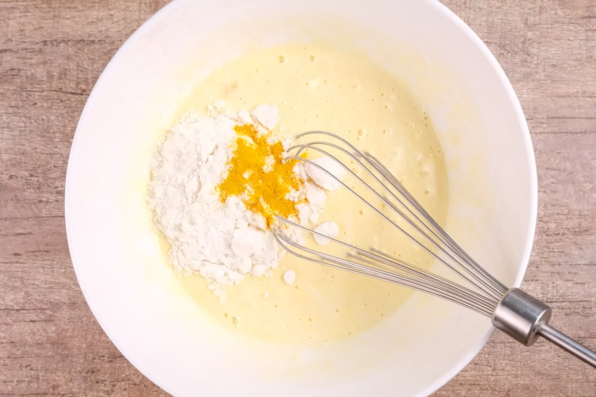 Whisking turmeric and coconut flour into the crepe batter.
