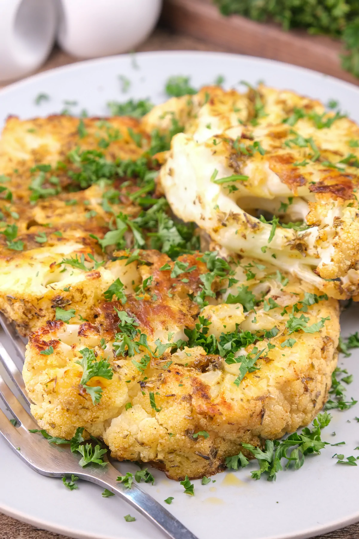A focused shot of cauliflower steak with coated with flavorful Creole-spiced butter.