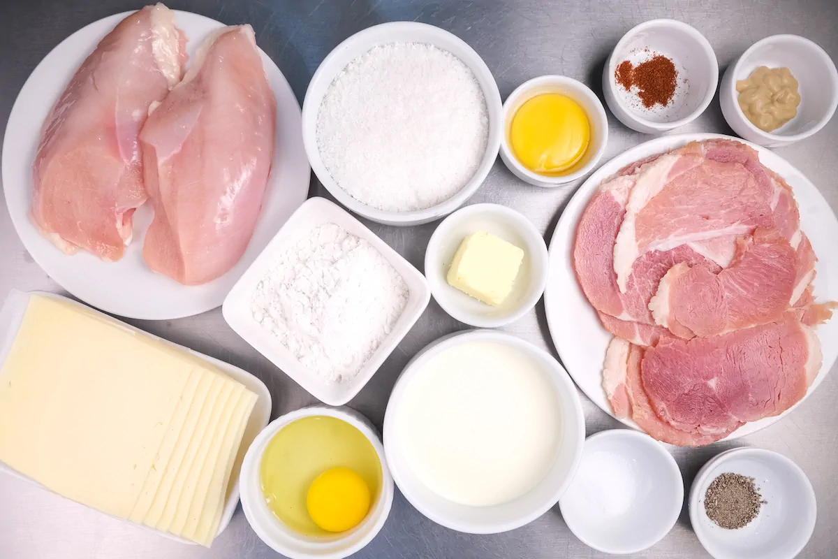 All the ingredients required to make the chicken cordon bleu gathered and arranged on the table.