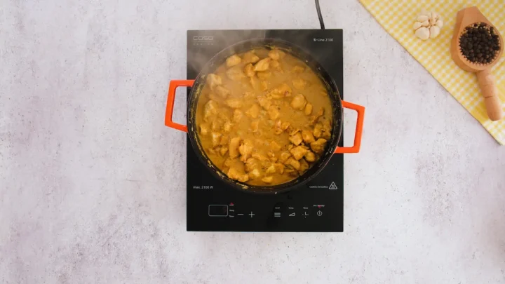 Simmering the boneless skinless chicken with yogurt mixture in an induction cooktop.