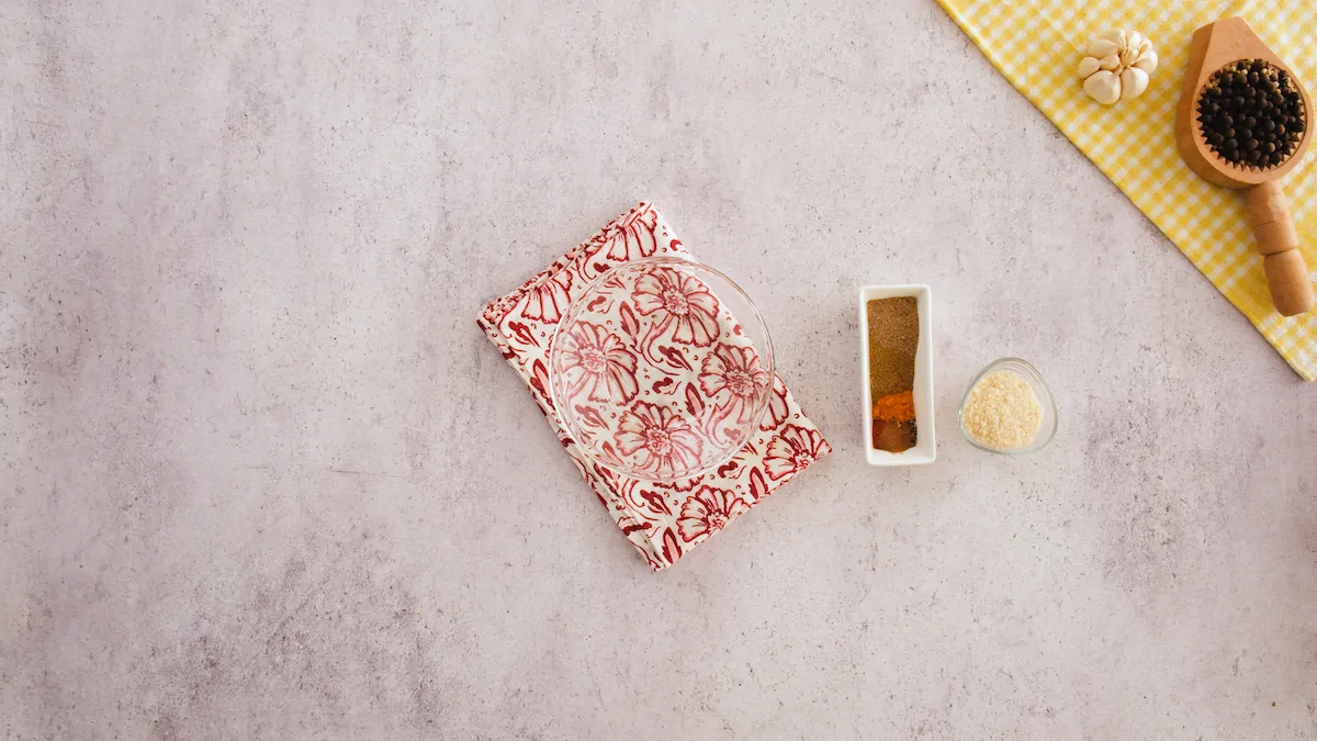 An empty bowl alongside a bowl of almond flour and a small rectangular platter with series of spices.