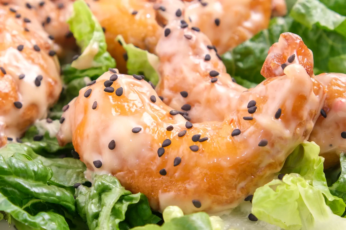 A focused shot of keto bang bang shrimp sprinkled with toasted sesame seeds.