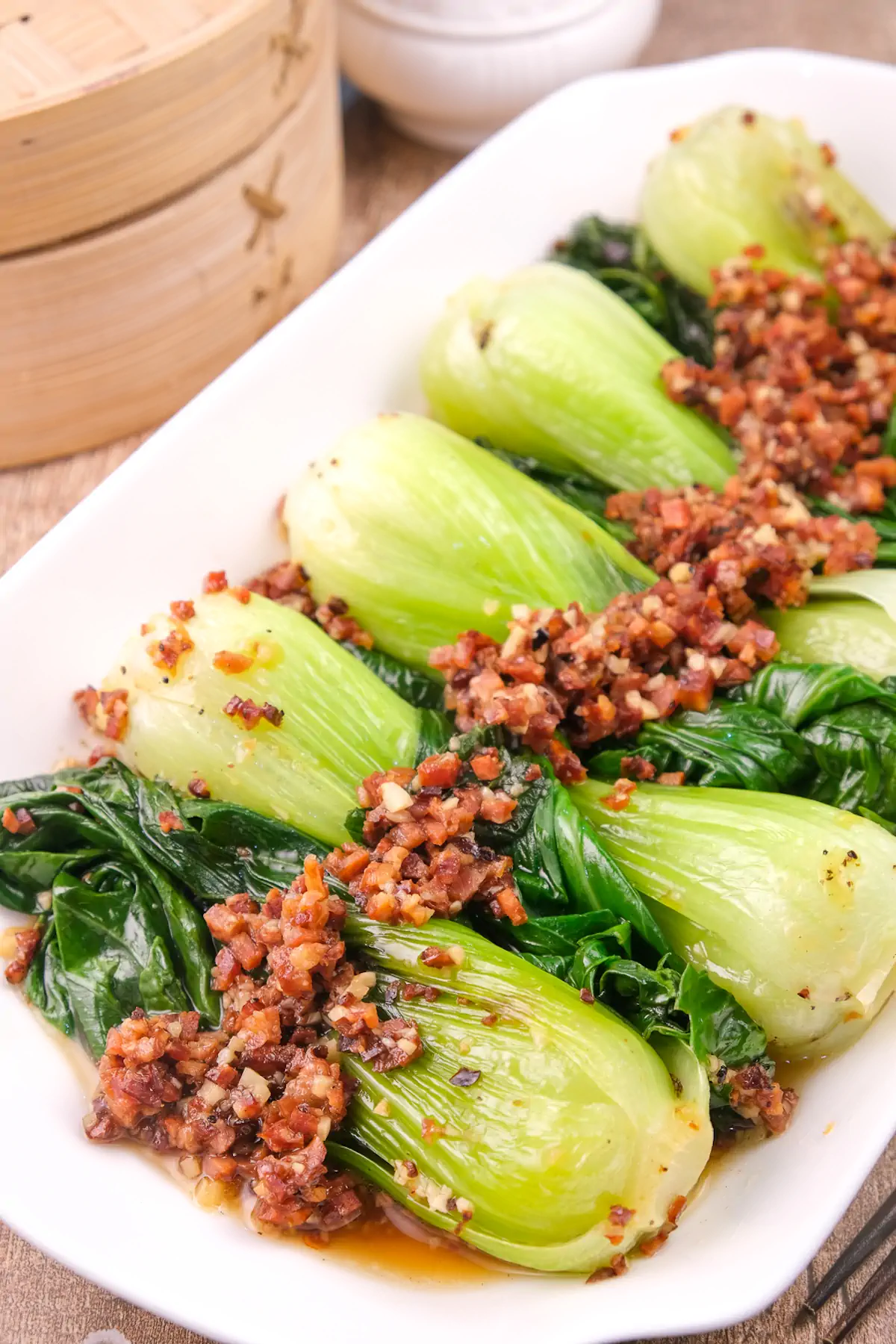 A rectangular white platter featuring keto bok choy and chorizo.