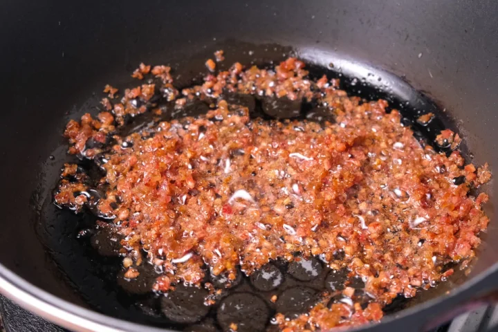 Cooking the chopped chorizo in a heated pan.