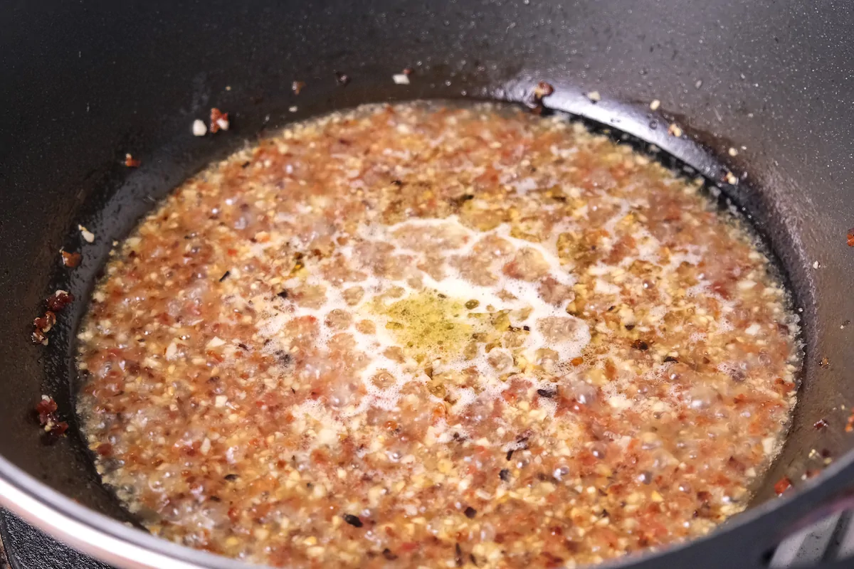 Chicken stock simmering with chorizo and aromatics.