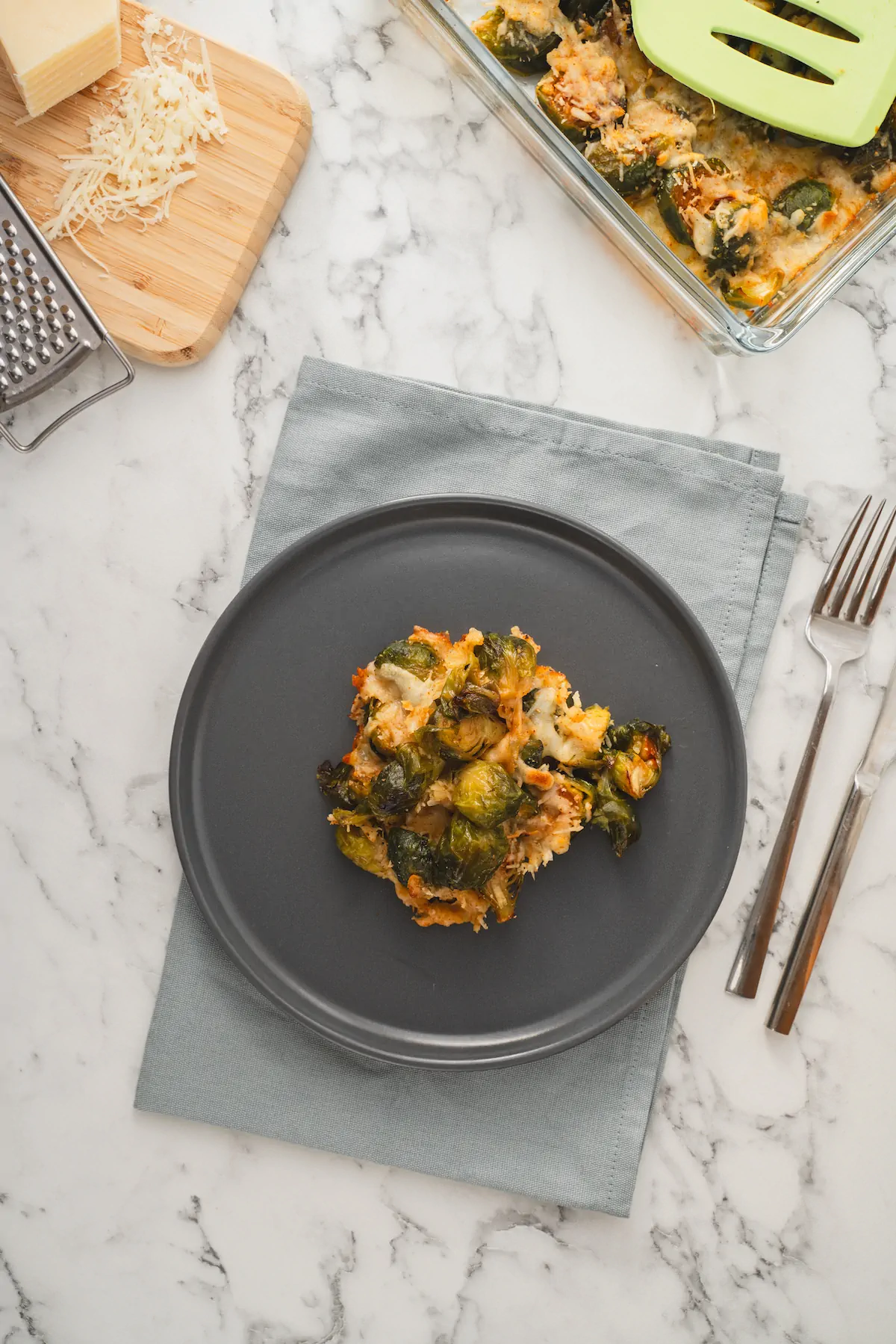 Homemade keto Brussels sprouts casserole served on a dark grey plate.